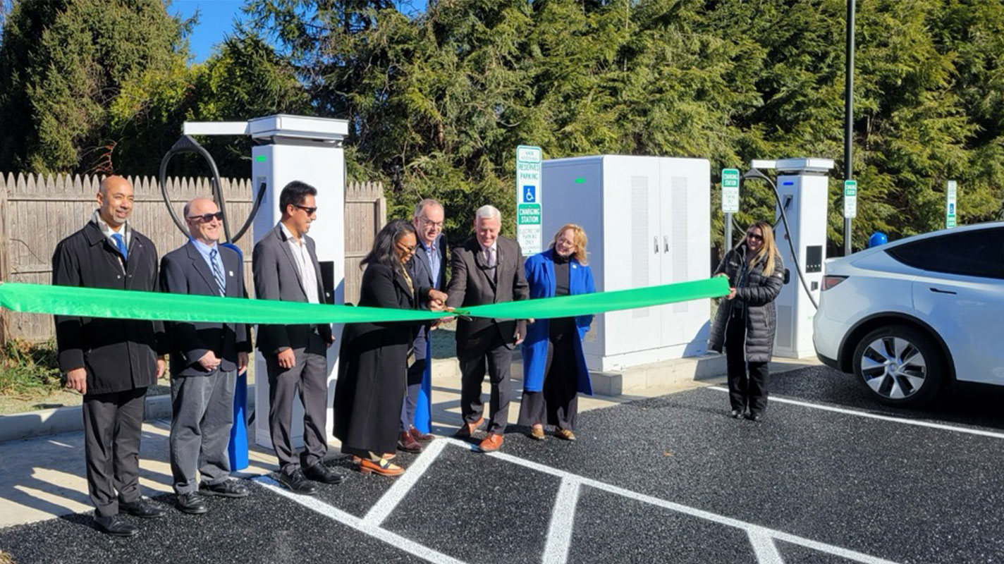 Ribbon cutting ceremony in front of EV chargers