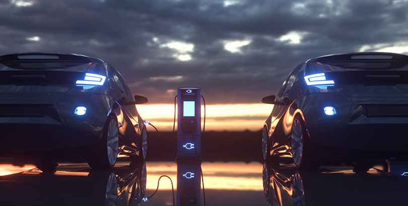 Two vehicles charging at sunset. 