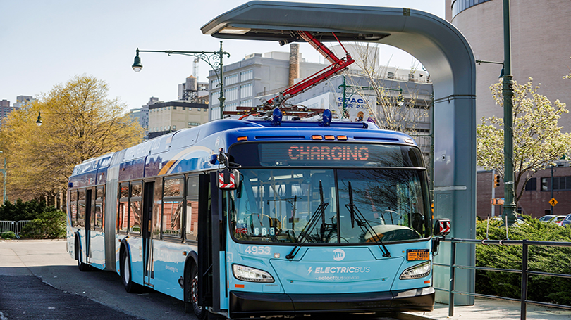Electric bus charging at station. 