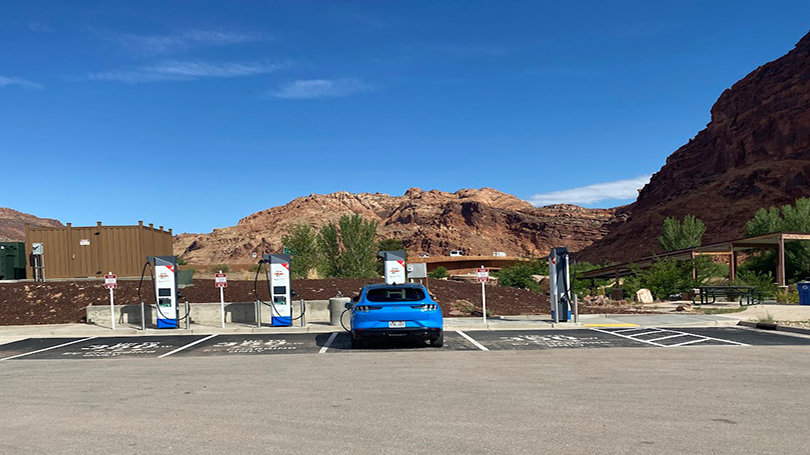 First NEVI station opens in Utah. Blue car charging. 