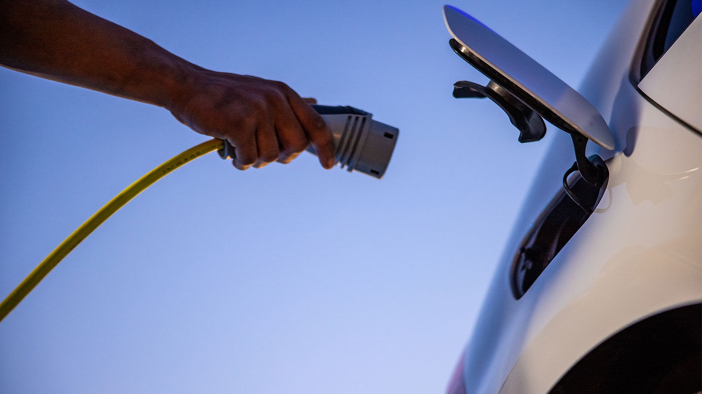 Person charging their electric vehicle