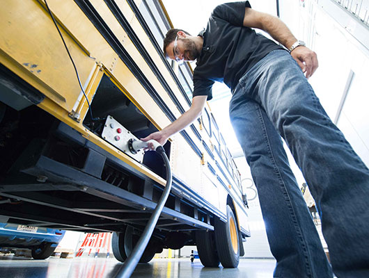 man plugging a bus in to charge