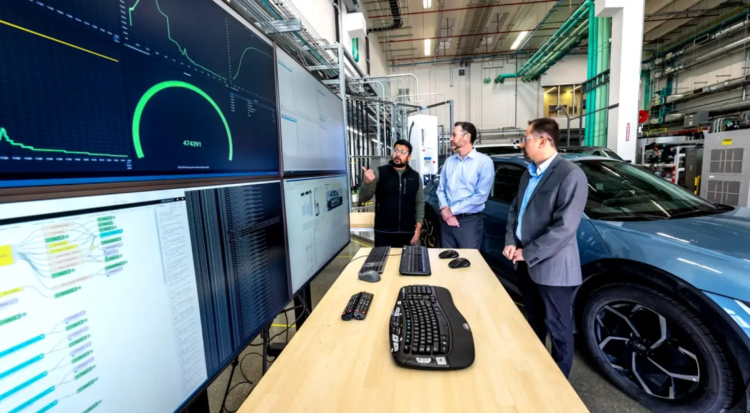 Three men looking at a dashboard of data visualizations