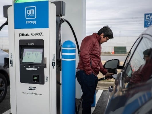 man charging electric vehicle